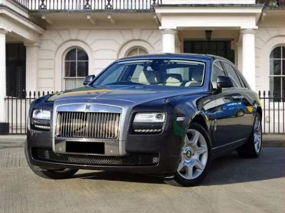 Blue luxury car parked outside a white building